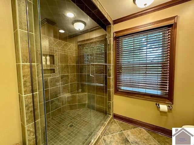 bathroom with ornamental molding, a shower with shower door, and tile patterned flooring