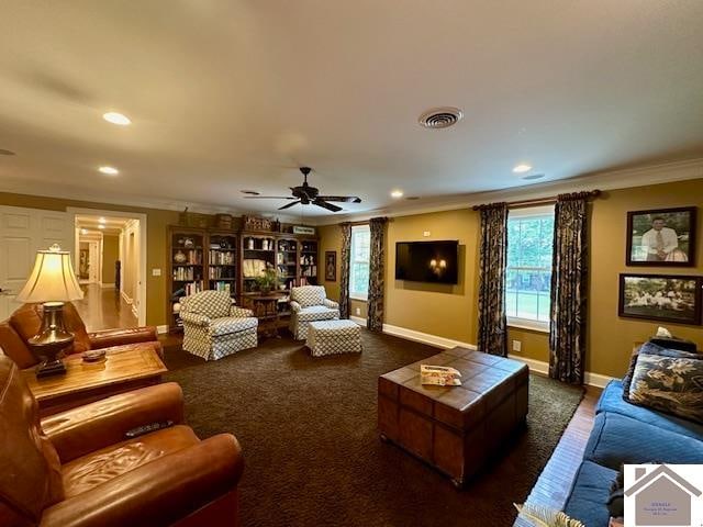 living room featuring ornamental molding, ceiling fan, and dark carpet