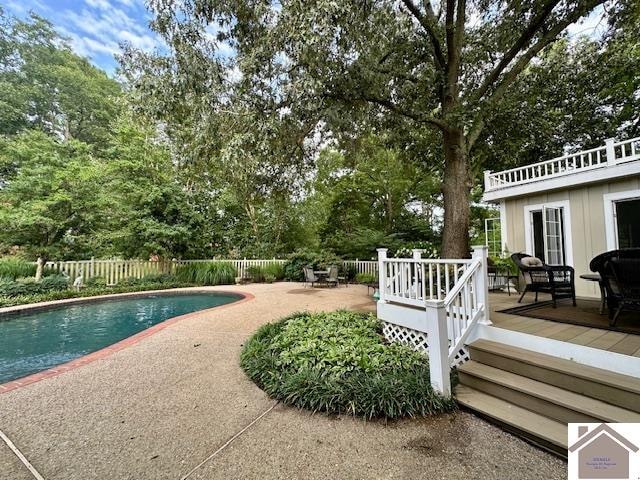 view of swimming pool featuring a patio area and a wooden deck