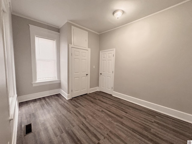 unfurnished bedroom featuring crown molding and dark hardwood / wood-style flooring