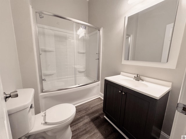 full bathroom with vanity, wood-type flooring, toilet, and combined bath / shower with glass door