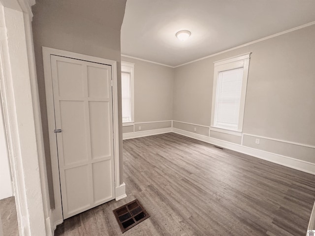 unfurnished room with dark wood-type flooring and ornamental molding