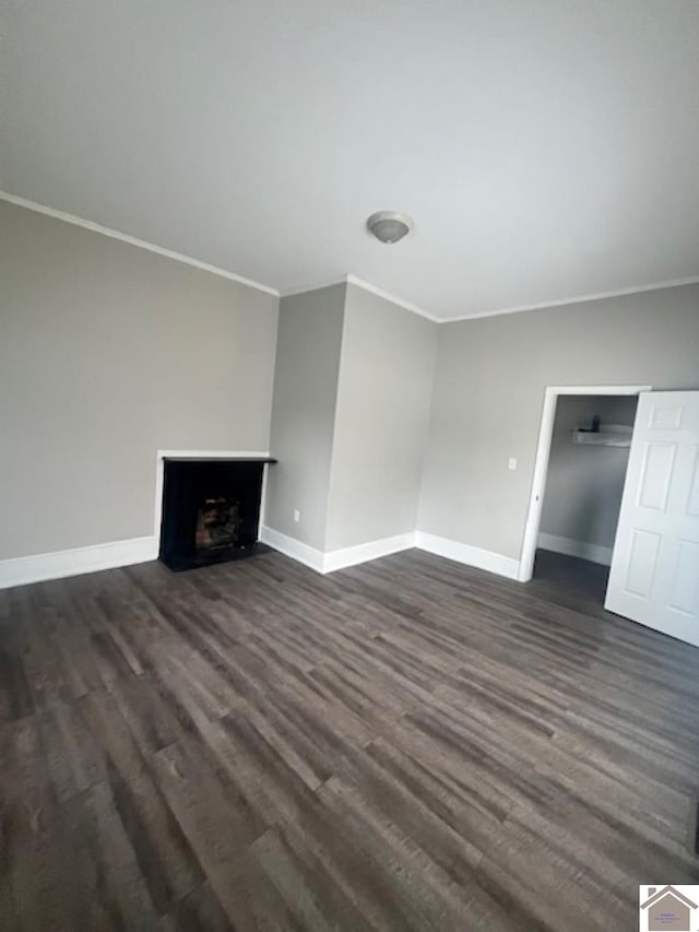 unfurnished living room featuring crown molding and dark hardwood / wood-style floors