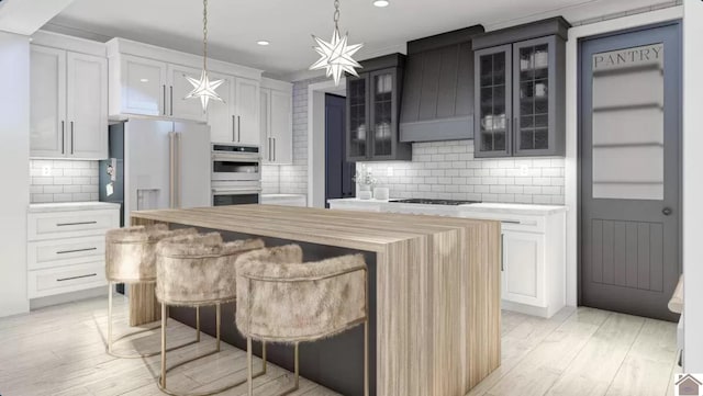 kitchen featuring high end fridge, light hardwood / wood-style floors, decorative backsplash, and a kitchen island