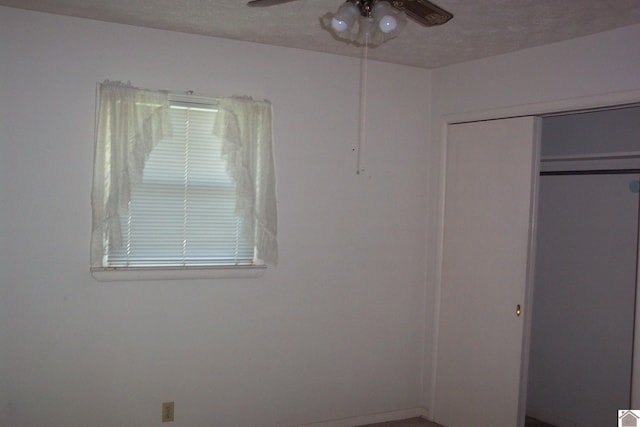 unfurnished bedroom featuring ceiling fan and a closet