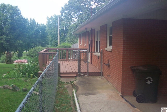 view of home's exterior with a wooden deck and a lawn