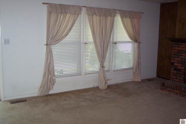 unfurnished living room featuring carpet flooring and a wealth of natural light