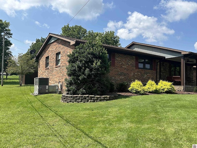 view of property exterior with a yard and central AC