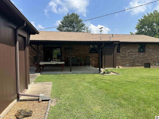 rear view of house with a yard and a patio