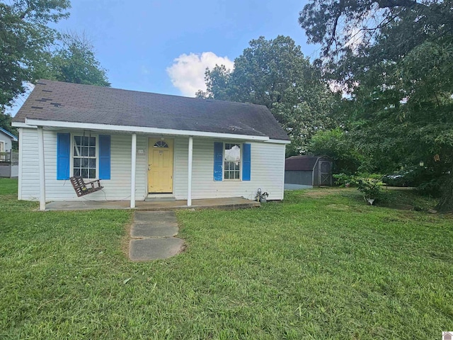 view of front of home with a storage shed, a porch, and a front yard