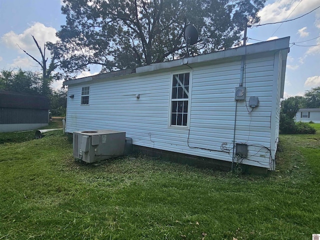 back of house featuring a lawn and central AC unit