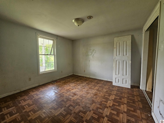 unfurnished room with dark parquet flooring