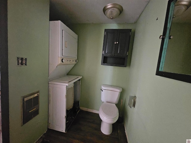 laundry area with electric panel, dark wood-type flooring, and stacked washer / drying machine