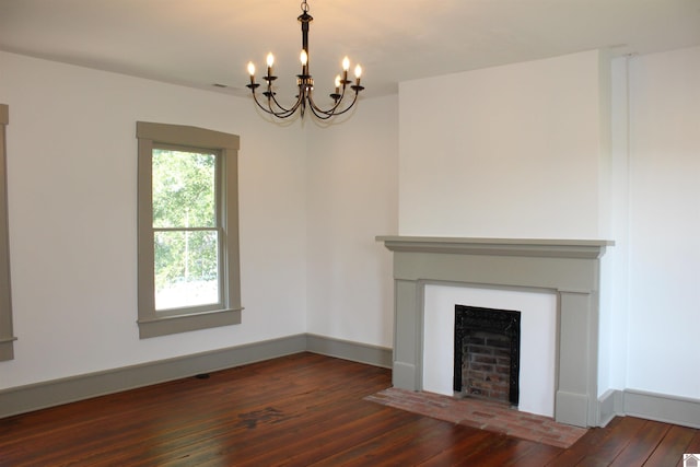 unfurnished living room featuring a notable chandelier and hardwood / wood-style flooring