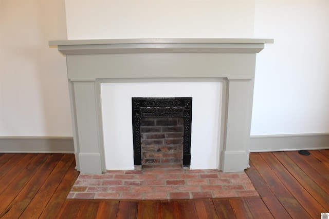 interior details featuring hardwood / wood-style floors and a brick fireplace