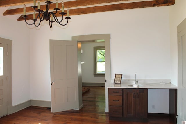 kitchen featuring beam ceiling, dark hardwood / wood-style floors, sink, and an inviting chandelier