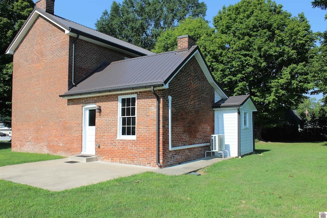 back of property with a lawn and a patio