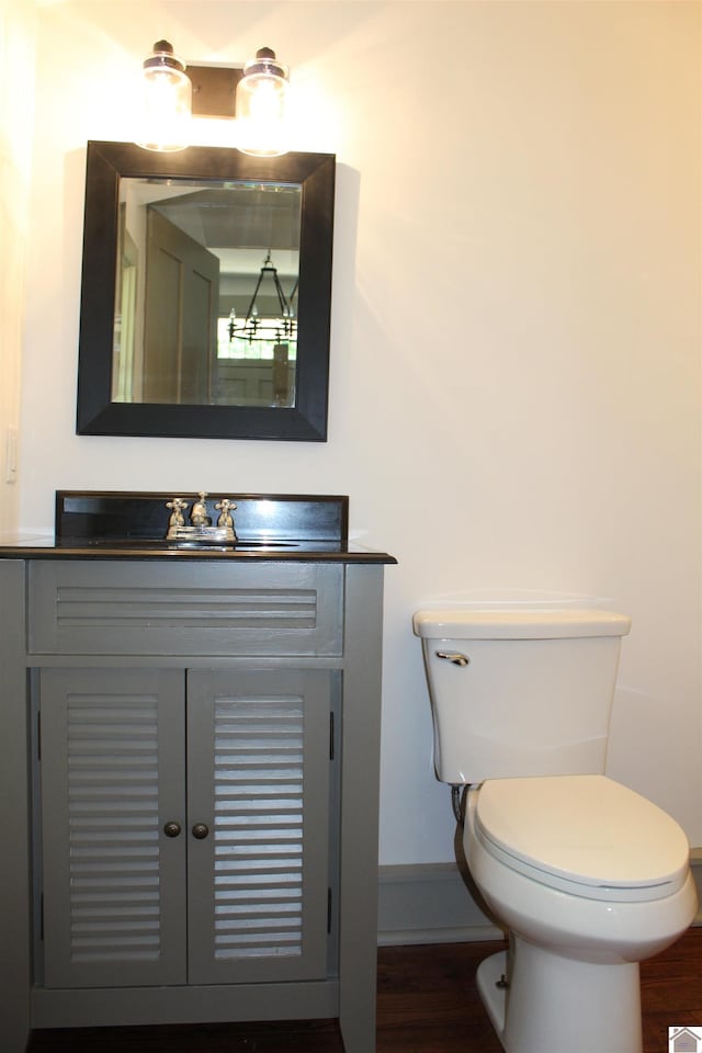 bathroom with hardwood / wood-style floors, vanity, and toilet