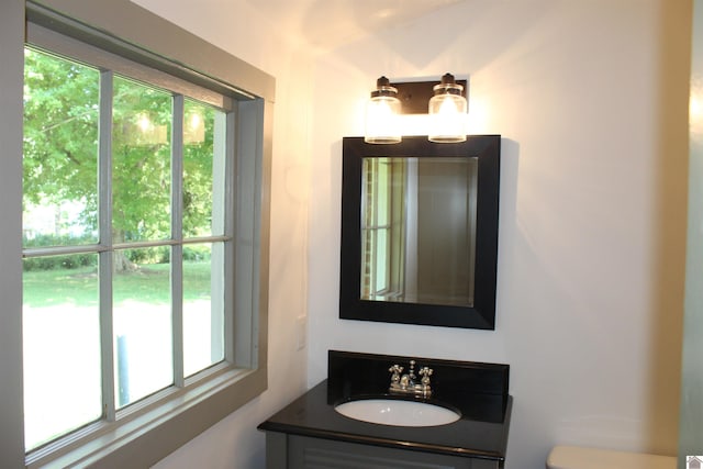 bathroom with vanity, toilet, and plenty of natural light