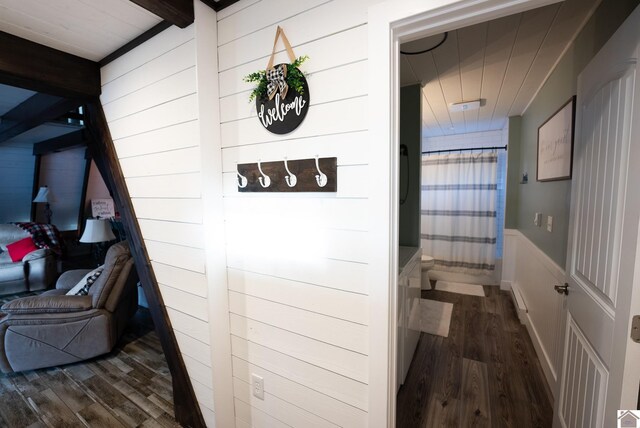 corridor featuring beam ceiling and dark hardwood / wood-style flooring