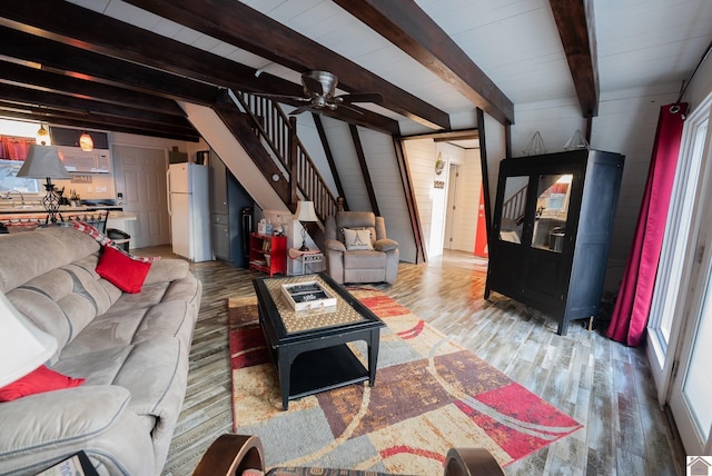 living room featuring sink, plenty of natural light, beamed ceiling, and light wood-type flooring