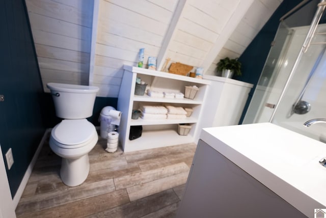 bathroom with lofted ceiling, hardwood / wood-style floors, a shower, and toilet