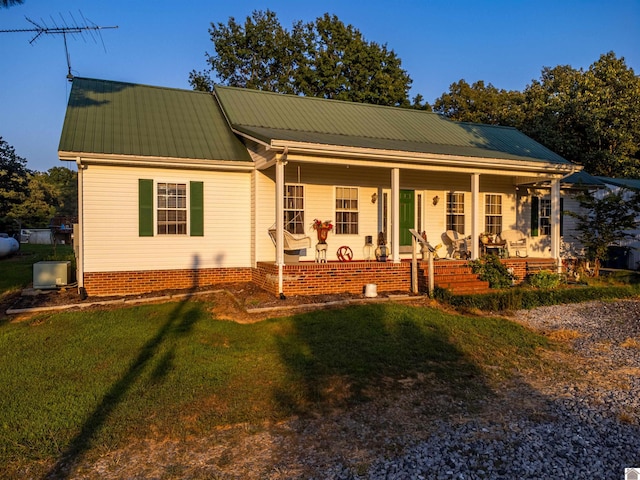 view of front of home with covered porch and a front lawn