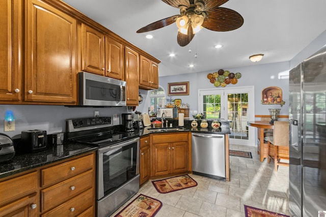 kitchen featuring sink, ceiling fan, appliances with stainless steel finishes, french doors, and dark stone counters