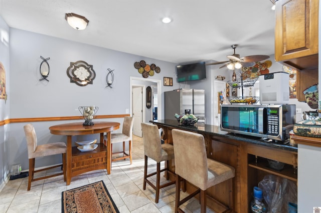 kitchen with stainless steel appliances, light tile patterned floors, and ceiling fan