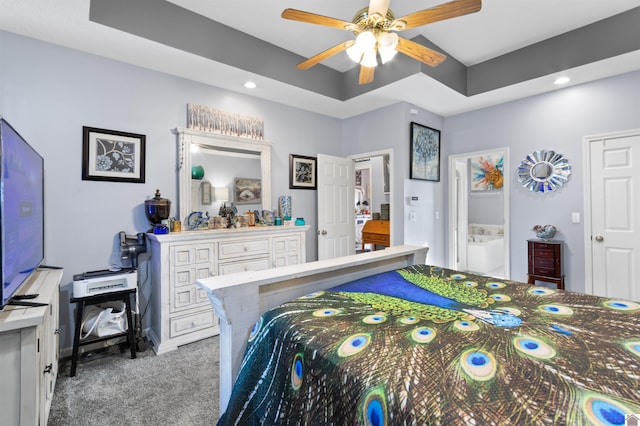 bedroom with carpet flooring, ceiling fan, and a tray ceiling