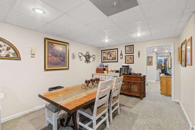 dining room featuring a paneled ceiling and light carpet