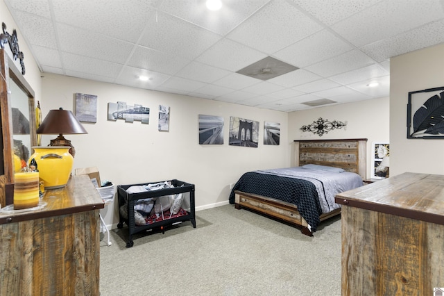 bedroom featuring a paneled ceiling and light carpet