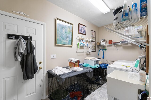 laundry room featuring light tile patterned flooring, sink, and washing machine and clothes dryer