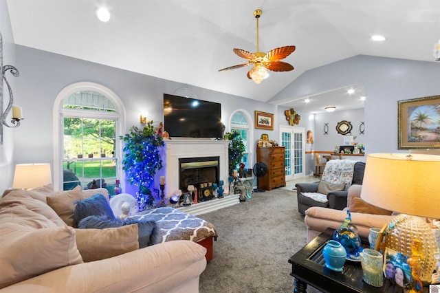 carpeted living room with ceiling fan and vaulted ceiling