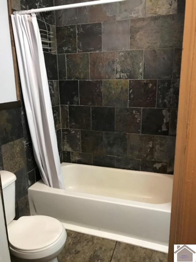 bathroom with tile patterned floors, toilet, and shower / bath combination with curtain