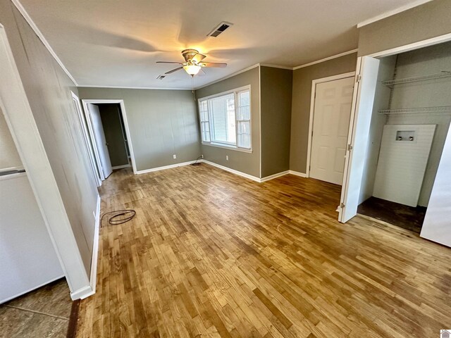 spare room featuring ceiling fan, wood-type flooring, and ornamental molding