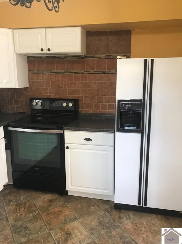 kitchen featuring dark tile patterned floors, white cabinets, white refrigerator with ice dispenser, backsplash, and black electric range