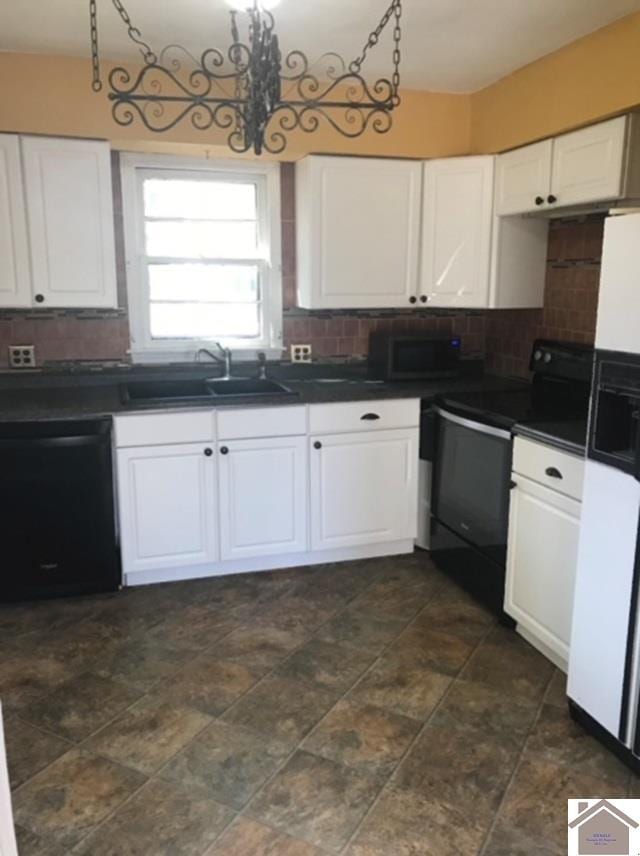 kitchen with dark tile patterned floors, white cabinets, black appliances, backsplash, and sink