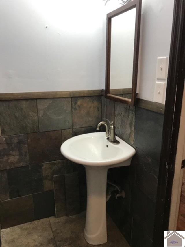 bathroom with tile patterned floors and tile walls