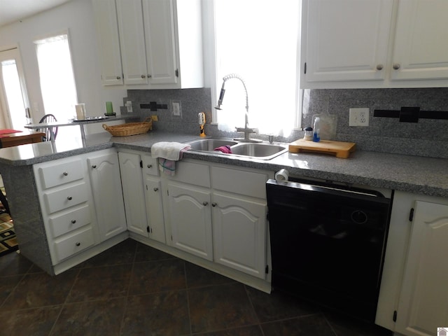 kitchen with black dishwasher, sink, tasteful backsplash, dark tile patterned flooring, and white cabinetry