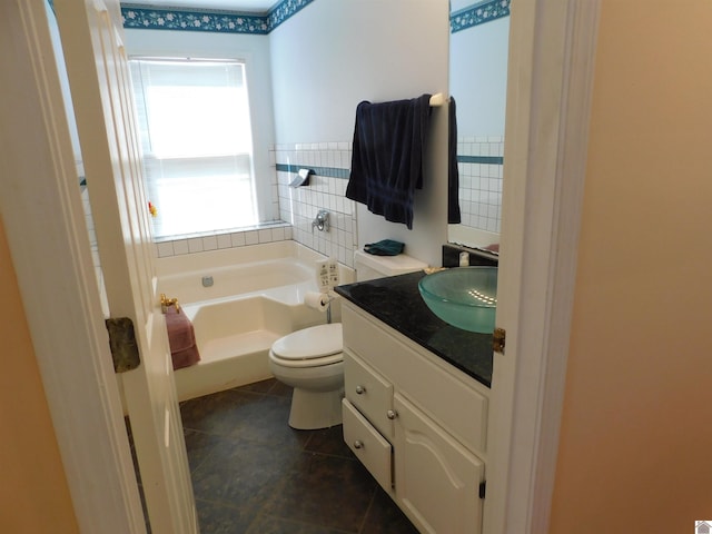 bathroom with toilet, tile patterned floors, vanity, and a bath