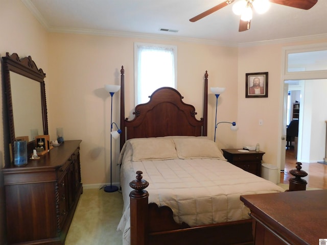 bedroom with ceiling fan, light colored carpet, and crown molding