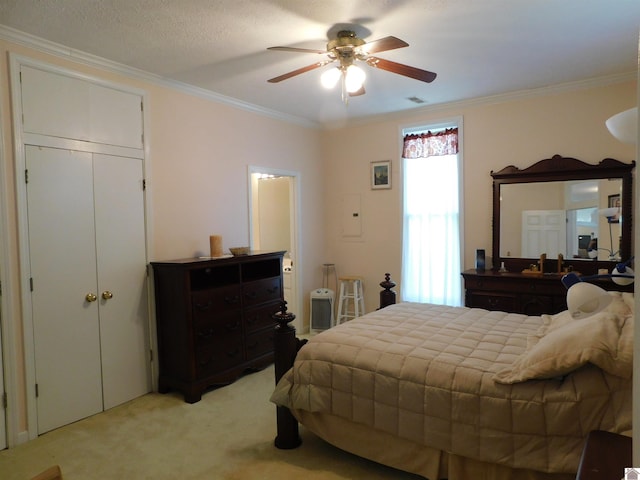 carpeted bedroom featuring a textured ceiling, crown molding, and ceiling fan