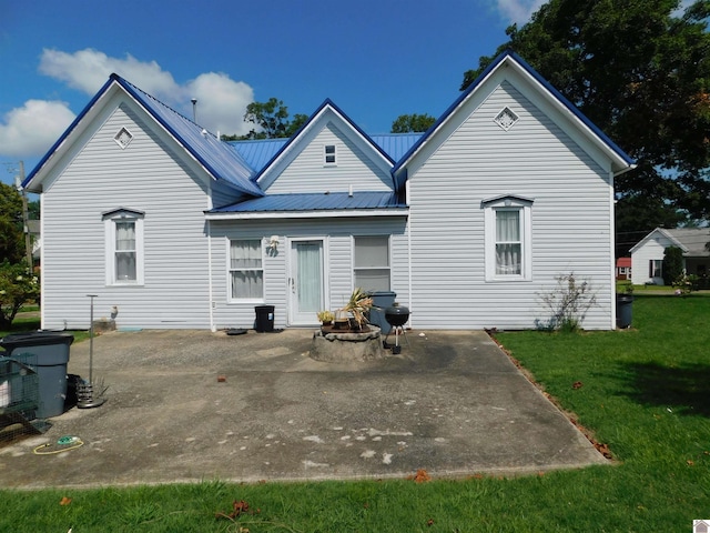 back of property featuring a lawn and a patio area