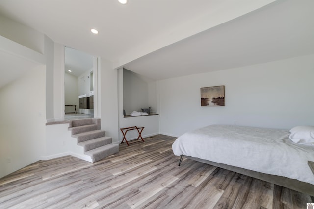 bedroom with wood-type flooring and vaulted ceiling