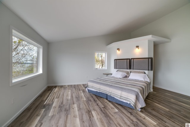 bedroom with lofted ceiling and hardwood / wood-style floors