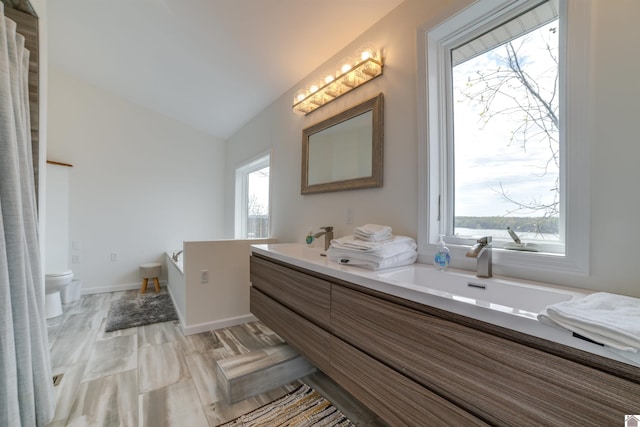 bathroom with lofted ceiling, tile patterned floors, double vanity, and toilet