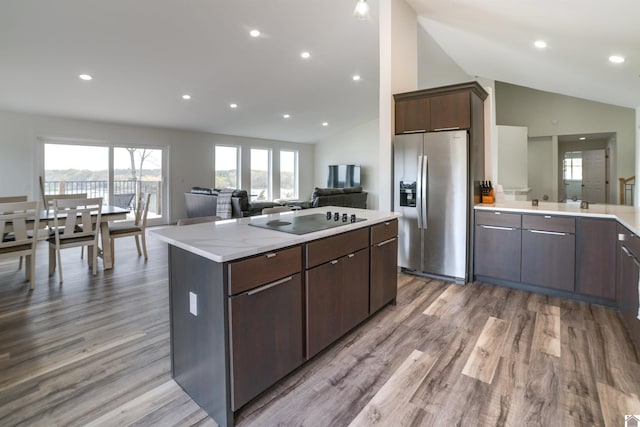 kitchen with dark brown cabinets, black electric cooktop, stainless steel refrigerator with ice dispenser, and light hardwood / wood-style floors