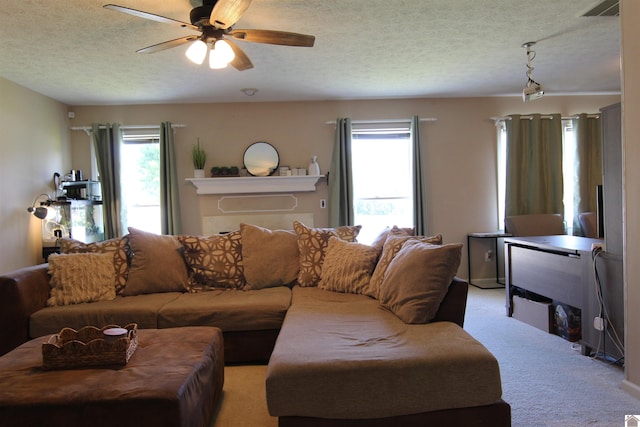 living room with ceiling fan, a textured ceiling, plenty of natural light, and light colored carpet