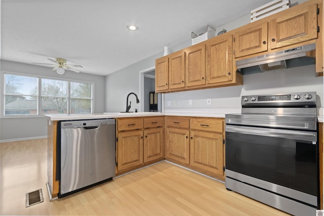 kitchen with sink, ceiling fan, kitchen peninsula, stainless steel appliances, and light wood-type flooring